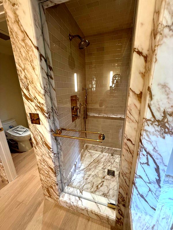 Marble-clad shower with brass fixtures
